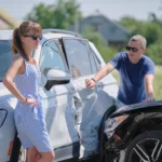 Angry woman and man drivers of damaged vehicles arguing who is guilty in car crash