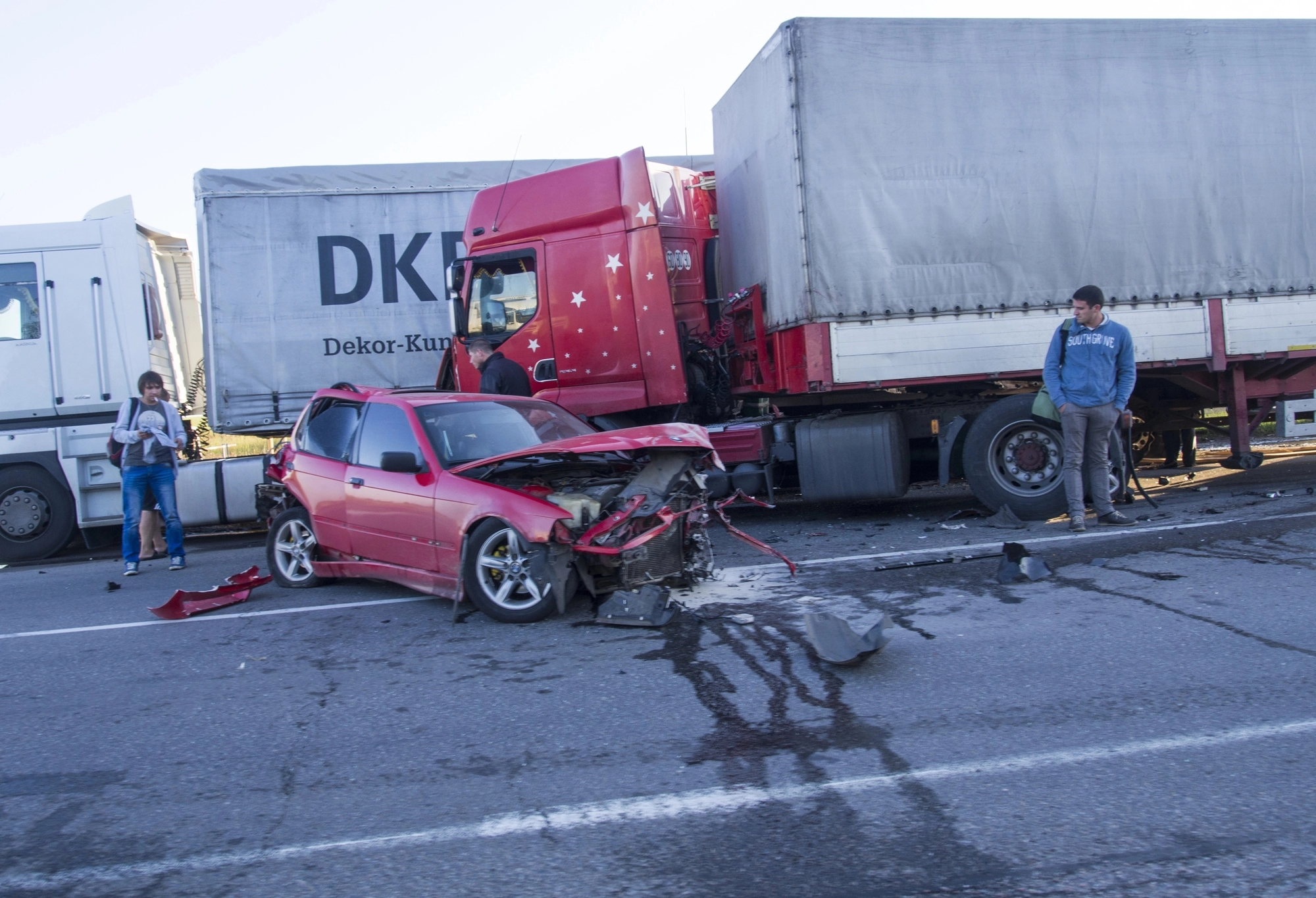 The aftermath of a truck accident with damaged car in the middle of the road